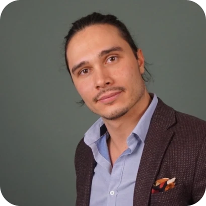 Yves Rogele, ein junger Mann im Business-Outfit mit Sakko und offenem Hemd, vor einem grünen Hintergrund.